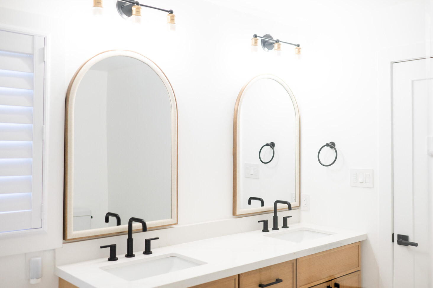 Renovated bathroom with arched mirrors and double undermount sinks in Bowmanville, Ontario